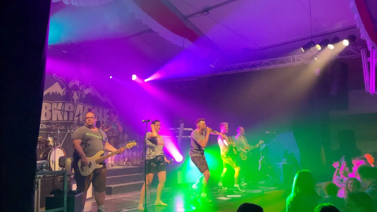 Die Band Albkracher spielt bei bunter Lichtshow auf der Bühne im Festzelt, im Vordergrund feiert das Publikum